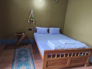 a bedroom with a wooden bed with a white mattress at La Bella Hotels and Resorts in Purulia