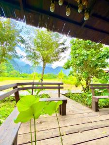 a wooden bench sitting on top of a wooden deck at Dalasone Pool Villas with Stunning Mountain Views in Vang Vieng +29 photos