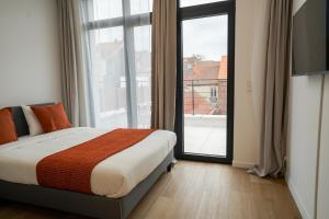 une chambre avec un lit et une grande fenêtre dans l'établissement Appartment Veeweyde 5, à Bruxelles