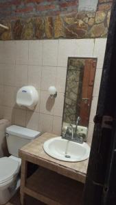 a bathroom with a sink and a toilet and a mirror at la chiponga beach hostel in Altagracia
