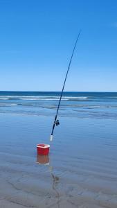 a fishing rod and a box on the beach at Casablanca in Dwarskersbos