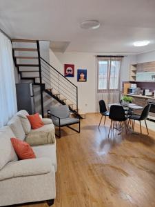 een woonkamer met een bank en een trap bij Kisház in Kisvárda