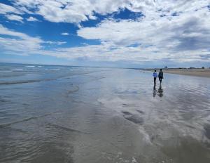 two people are walking on the beach at Casablanca in Dwarskersbos