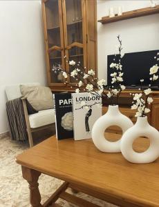 two white vases sitting on a wooden table at Espera Apartamentos in Espera