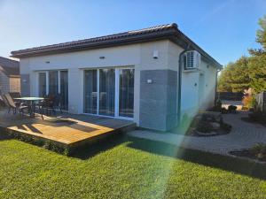 a house with a deck and a table in the yard at Svečių namas in Radailiai