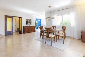 ein Esszimmer und ein Wohnzimmer mit Tisch und Stühlen in der Unterkunft Almarda Beach House in Almardá