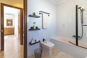 ein Badezimmer mit Badewanne, Toilette und Waschbecken in der Unterkunft Almarda Beach House in Almardá + 54 Fotos