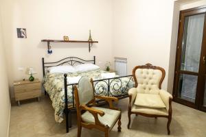 a bedroom with a bed and two chairs and a table at View, Terrace & Comfort in Sant'Agata de' Goti in SantʼAgata deʼ Goti