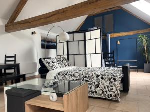 Un dormitorio con una cama y una mesa de cristal. en Le Merisier, 