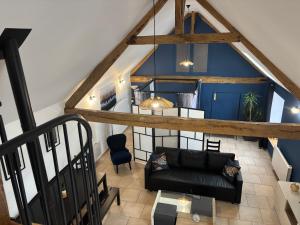 sala de estar con sofá negro y pared azul en Le Merisier, 