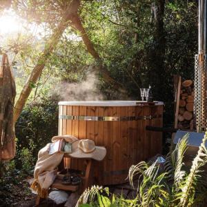 ein hölzerner Whirlpool mit einem Hut auf einem Tisch in der Unterkunft CORK VALLEY - Pet Friendly & Only Adults in Hontanar