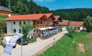 ein Gebäude mit vielen Tischen davor in der Unterkunft Berggasthof-Pension Seminar- und Tagungshaus Menauer in Grandsberg