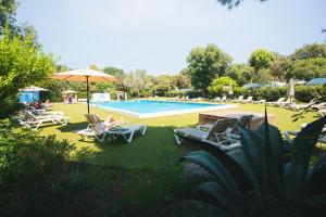 a person sitting in chairs by a swimming pool at HolaCamp Palamós in Vall-Llobrega +33 photos