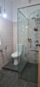 a bathroom with a toilet and a glass shower at Shane`s Home Stay in Katugastota