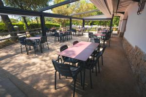 an outdoor patio with tables and chairs and windows at HolaCamp Palamós in Vall-Llobrega