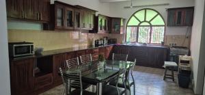 a kitchen with a glass table and chairs in it at Shane`s Home Stay in Katugastota