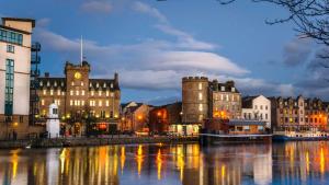 a city with buildings and a river at night at Matrix Hostel in Edinburgh