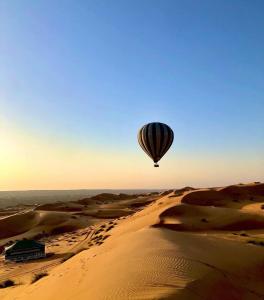 BadīyahRashid Desert Private Camp的飞过沙漠的热气球
