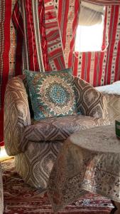 BadīyahRashid Desert Private Camp的客房内的沙发、枕头和桌子
