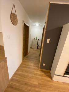 Un pasillo que conduce a una habitación con un reloj en la pared. en Nowy Apartament 4 Osob dobra lokalizacja Franciszkanska 300m z S6, en Koszalin
