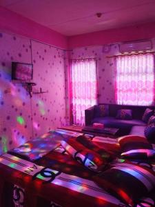 a bedroom with a bed in a room with pink lights at Penginapan Purple Syariah 