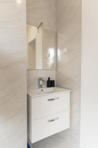a white bathroom with a sink and a mirror at Yassam Le 101- Appartement -Gare in Saint-Brieuc