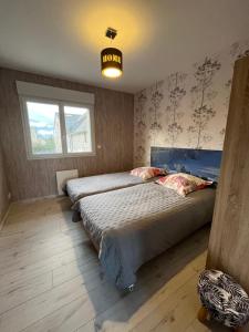 SalguesにあるGîte aux Portes d'Aubracのベッドが2つあり、「地平線」と書かれた看板のある寝室