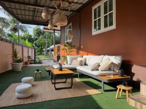 a living room with a white couch and tables at Hua Hin House in Hua Hin