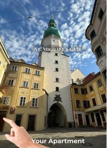 a person pointing at a building with a clock tower at Central Modern Studio - wifi, coffee in Bratislava