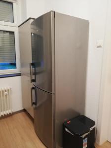 a stainless steel refrigerator in a room with a window at Gemütliche Erdgeschosswohnung mit 3 Einzelzimmern! in Niederdorla