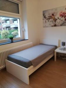 a bedroom with a bed in a room with a window at Gemütliche Erdgeschosswohnung mit 3 Einzelzimmern! in Niederdorla