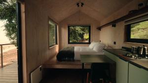 a bedroom with a bed in the middle of a house at Cabins entre bosques y viñedos con vistas al valle - Tucu cabins in Maipo