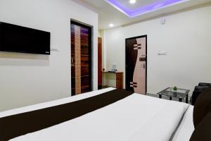 a bedroom with a bed and a tv on the wall at Hotel O SS INN in Bhubaneshwar