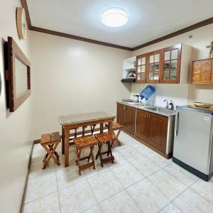 uma cozinha com uma mesa e uma geladeira em Spacious Studio Unit at Albergo Residences Baguio em Baguio
