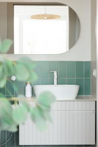 ein Badezimmer mit einem weißen Waschbecken und einem Spiegel in der Unterkunft SEN TOPOLI Domy nad jeziorem  + 36 Fotos