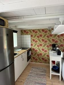 a kitchen with a floral wallpaper on the wall at Toftavägen 325 Semesterbostad in Tofta