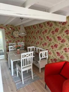 a dining room with a table and chairs and flowers at Toftavägen 325 Semesterbostad in Tofta +15 photos