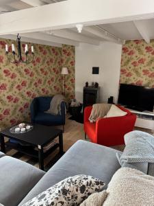 a living room with a couch and chairs and a tv at Toftavägen 325 Semesterbostad in Tofta