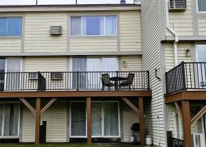 a house with a balcony with two chairs and a table at Sugar Baby (B6) in Cedar