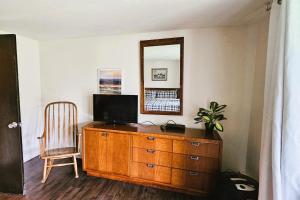 a room with a wooden dresser and a mirror at Sugar Baby (B6) in Cedar