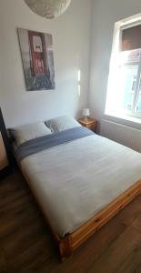 een groot bed in een slaapkamer met 2 ramen bij Old Town Apartment Bydgoszcz in Bydgoszcz