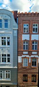 een hoog gebouw naast een bakstenen gebouw bij Old Town Apartment Bydgoszcz in Bydgoszcz +2 foto's