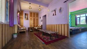 een woonkamer met een tafel in het midden van een kamer bij The City Escape Farmstay in Shimla