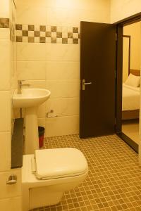 a bathroom with a toilet and a sink at The Royal Oak in Bhatkal