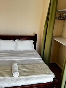 a bedroom with a bed with a roll of towels on it at Artesano one bedroom cozy and comfortable in Syokimau