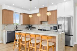 Palm IslandにあるAqua Verde Waterfront Gem Dock Game Roomのバースツール付きの大きな島のあるキッチンが備わります。