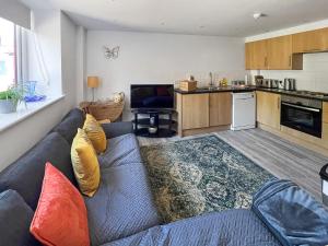 ein Wohnzimmer mit Couch und Küche in der Unterkunft Moglett Cottage in Fincham