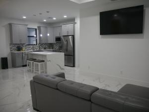 Snowball at the beach في كيب كورال: غرفة معيشة مع أريكة ومطبخ