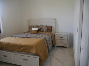 Snowball at the beach في كيب كورال: غرفة نوم مع سرير ونباتين ليلية وسرير سيد +7 صور