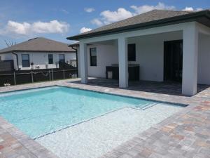 Snowball at the beach في كيب كورال: حمام سباحة أمام منزل